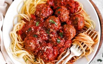 white plate with spaghetti and meatballs