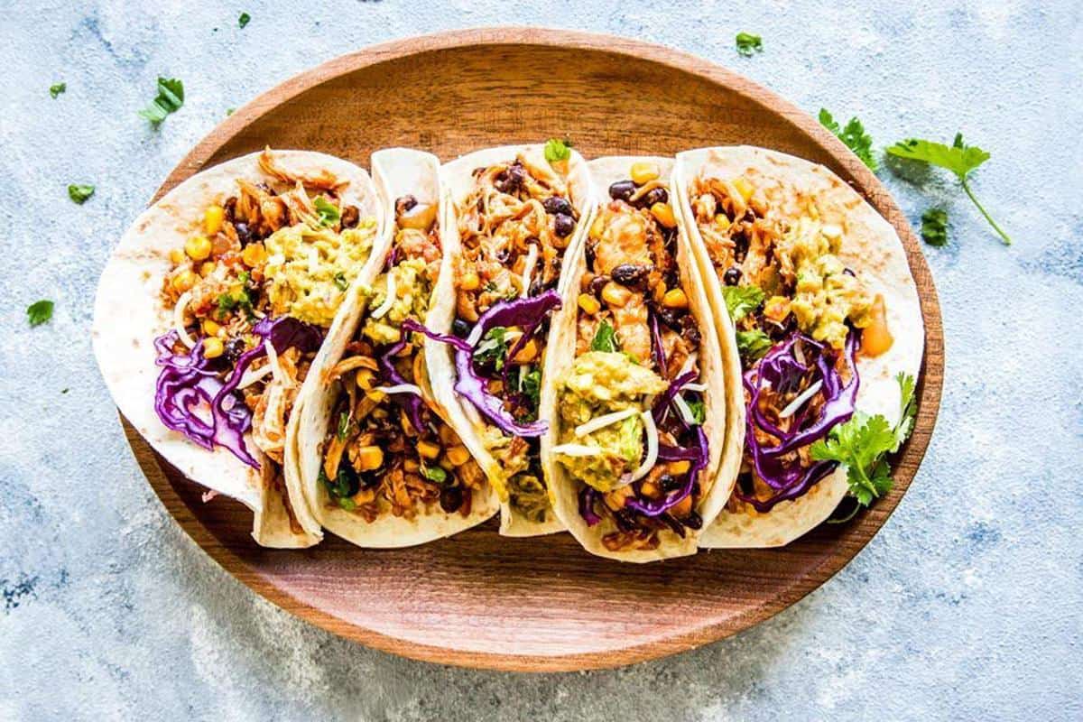 southwestern crockpot chicken tacos on a wooden platter