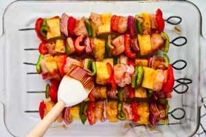 brushing bbq sauce on kabobs