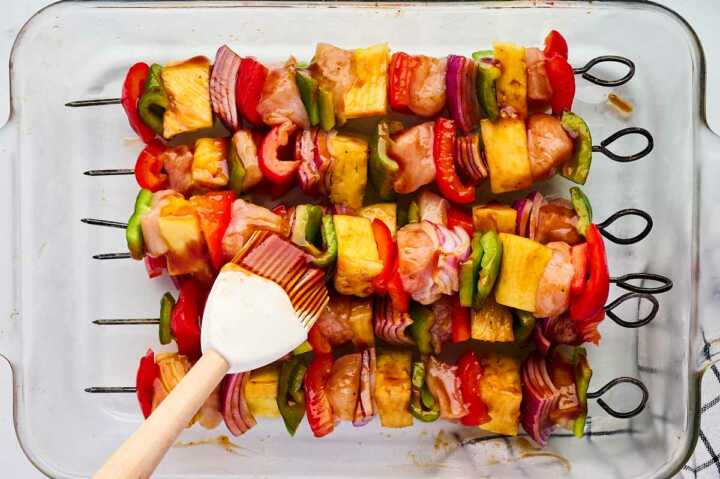 brushing bbq sauce on kabobs