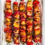 pineapple bbq chicken kabobs on lined sheet pan