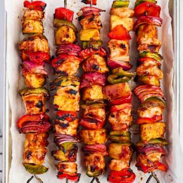 pineapple bbq chicken kabobs on lined sheet pan