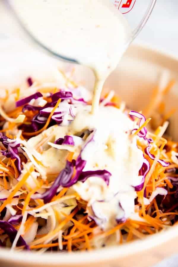 pouring dressing over coleslaw mix