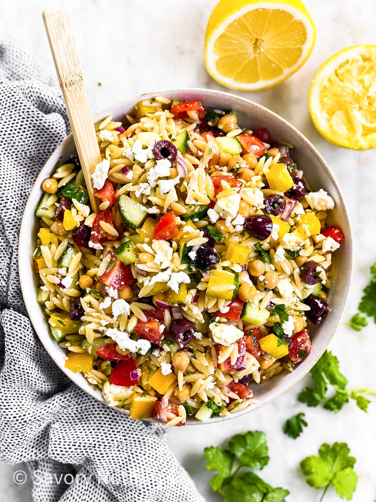 overhead view of greek orzo salad in white bowl