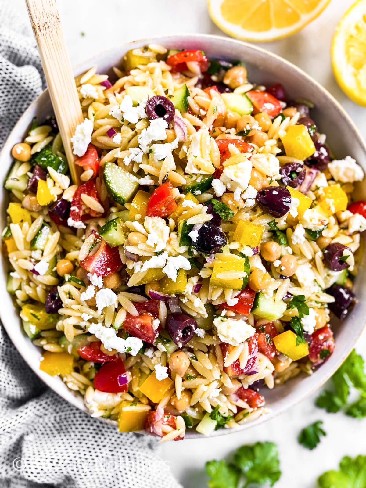 overhead view of white bowl filled with Greek orzo salad