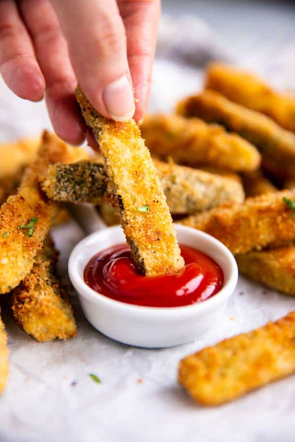 dipping a zucchini fry in ketchup