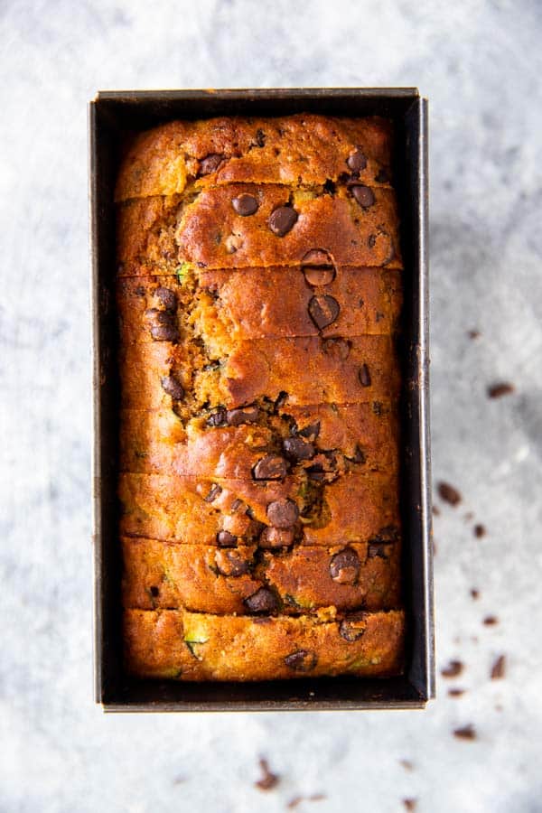 loaf pan with a sliced chocolate chip zucchini bread inside