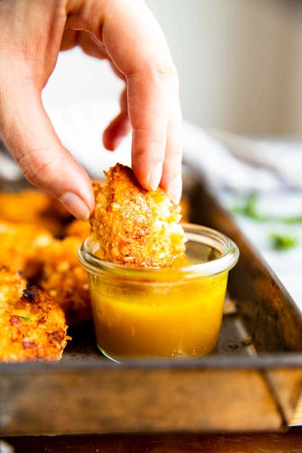 dipping coconut chicken in honey mustard sauce