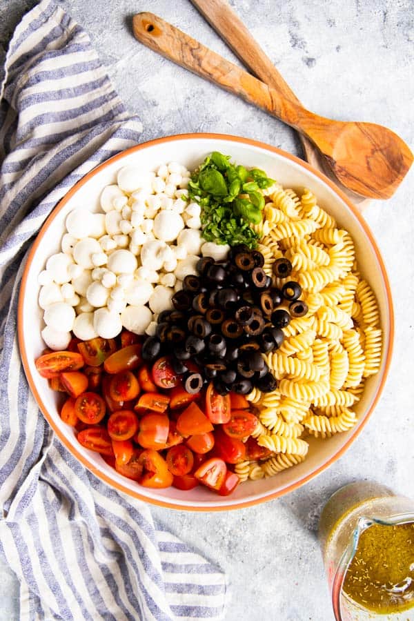 ingredients for pesto pasta salad in a bowl