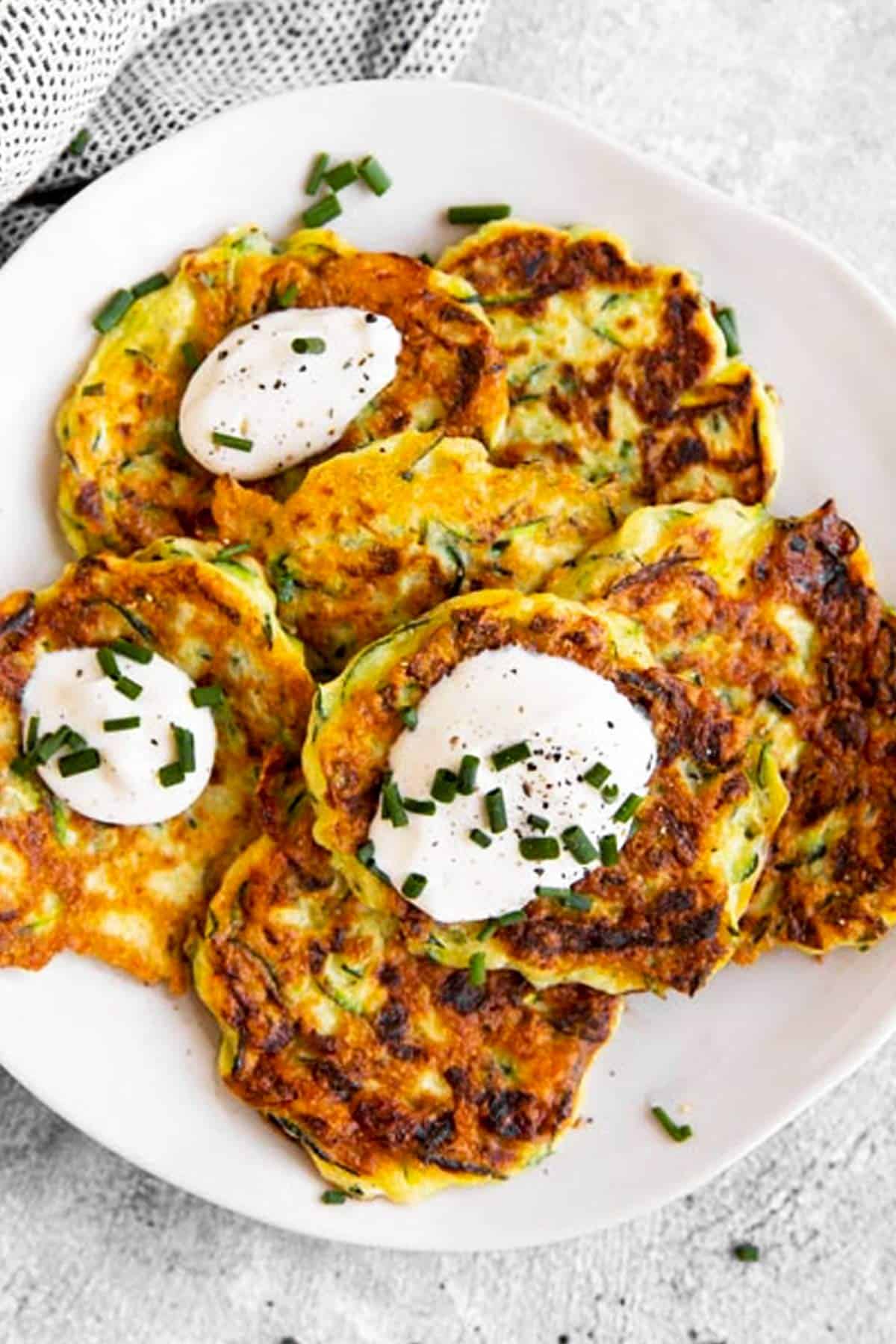 overhead view of zucchini fritters on white plate