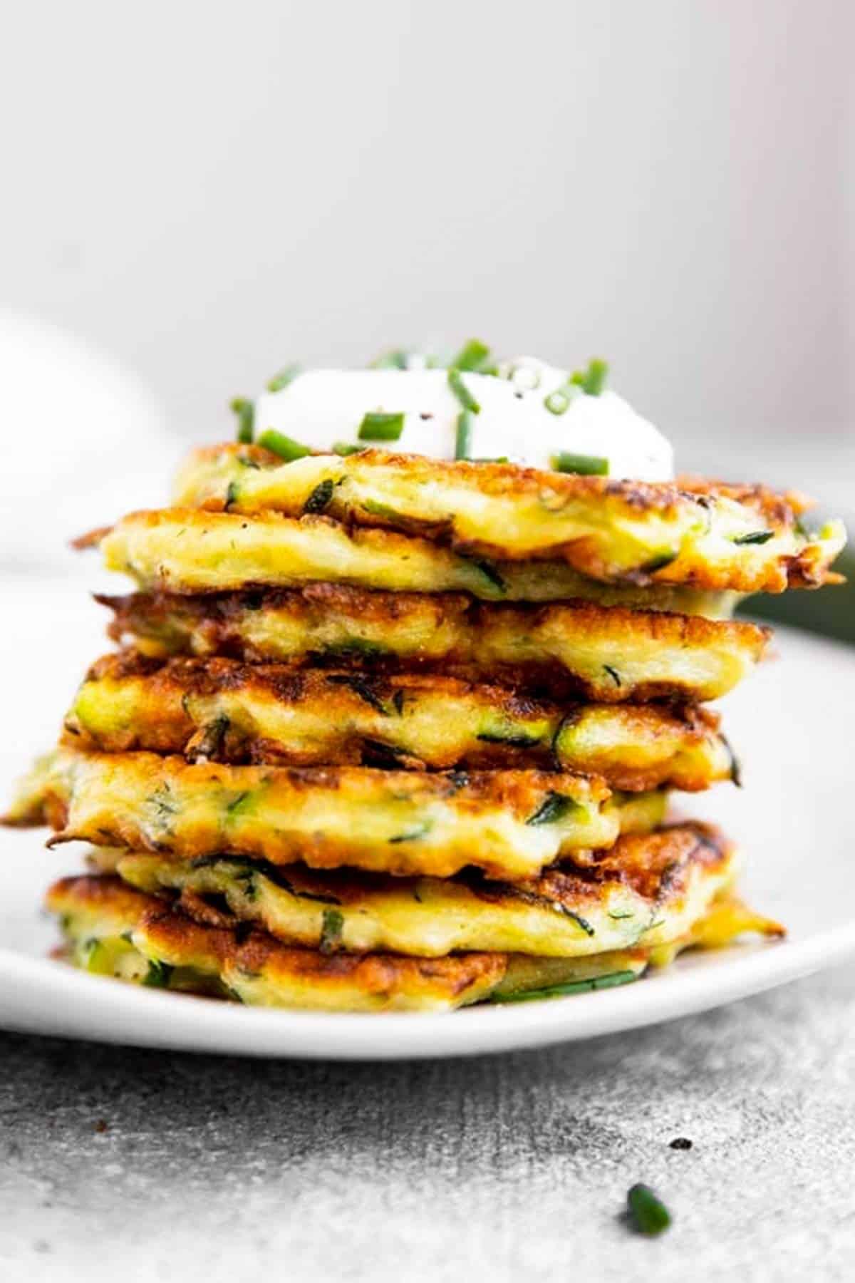 stack of zucchini fritters on white plate