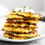 stack of zucchini fritters on white plate