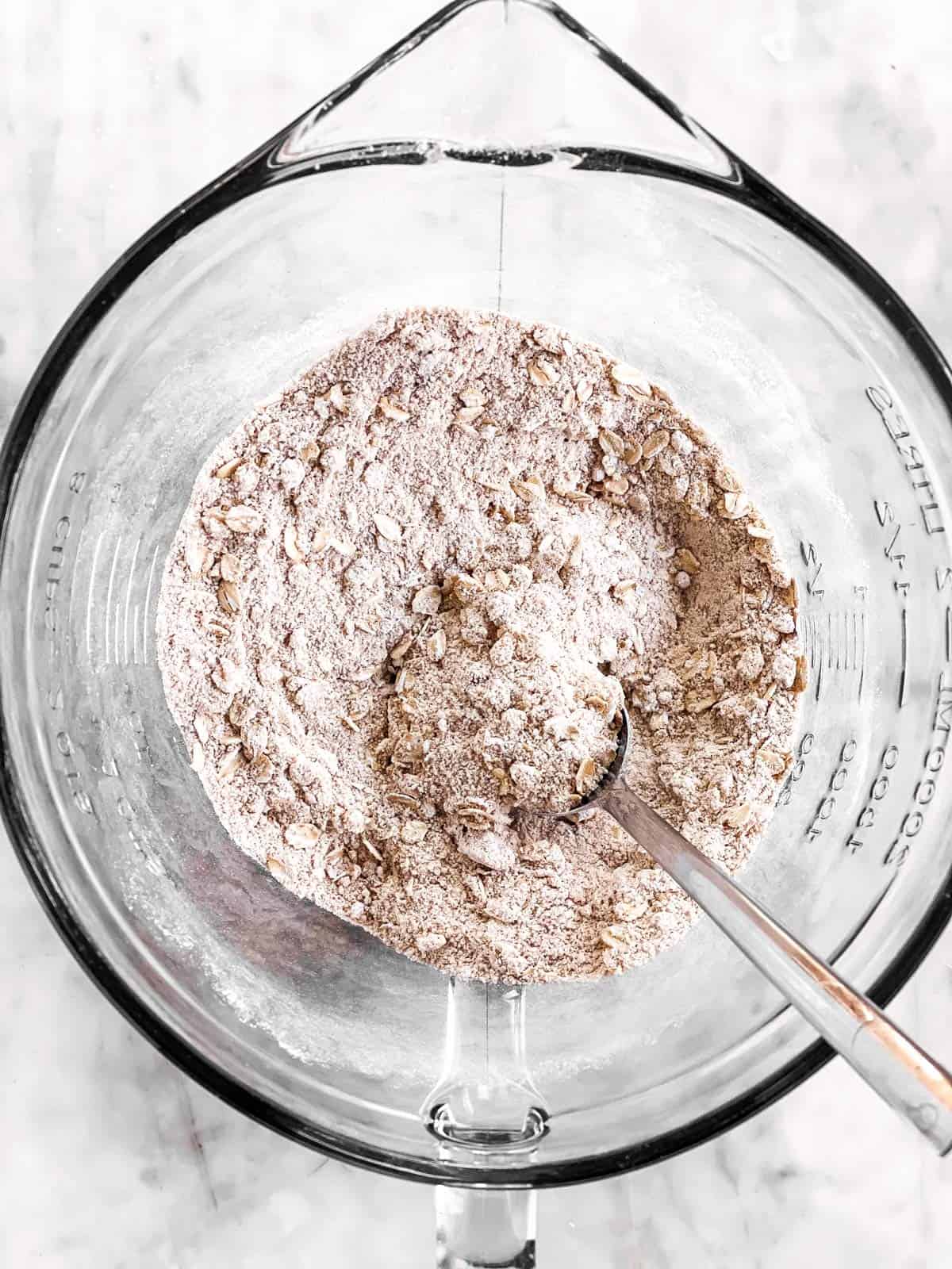 combined dry ingredients for apple crisp topping in a glass bowl