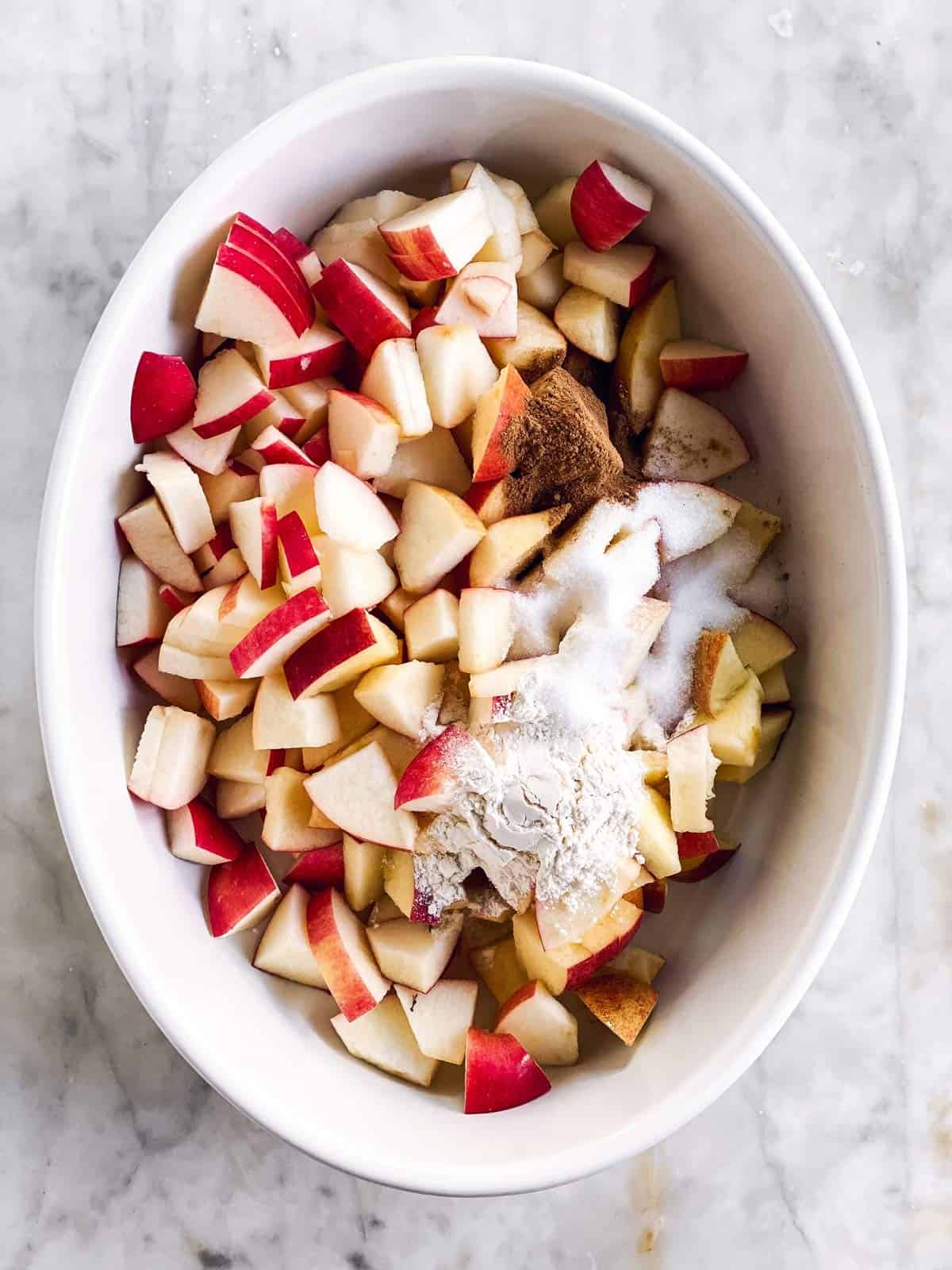 white dish with apples, sugar and cinnamon