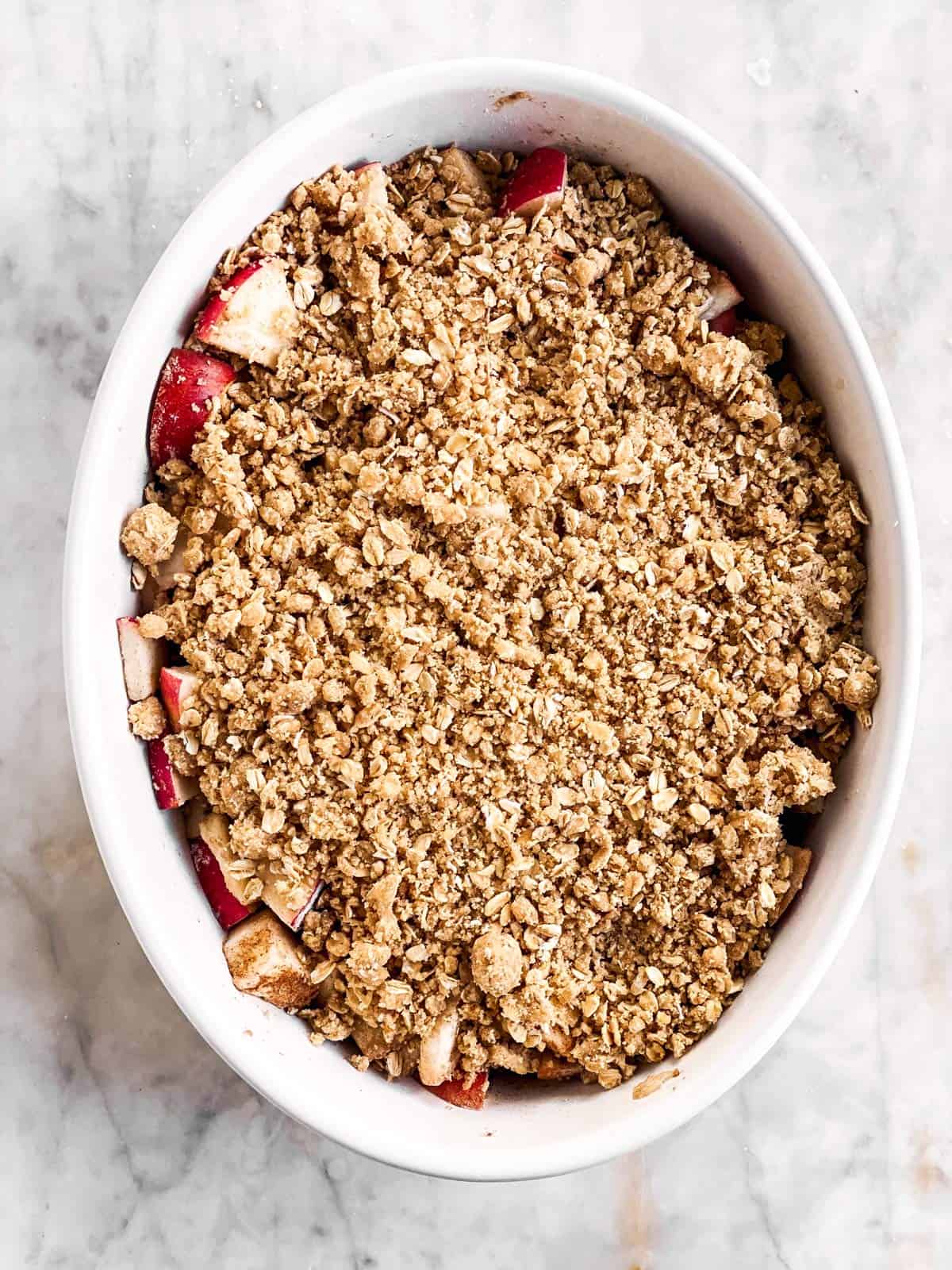 unbaked apple crisp in white baking dish