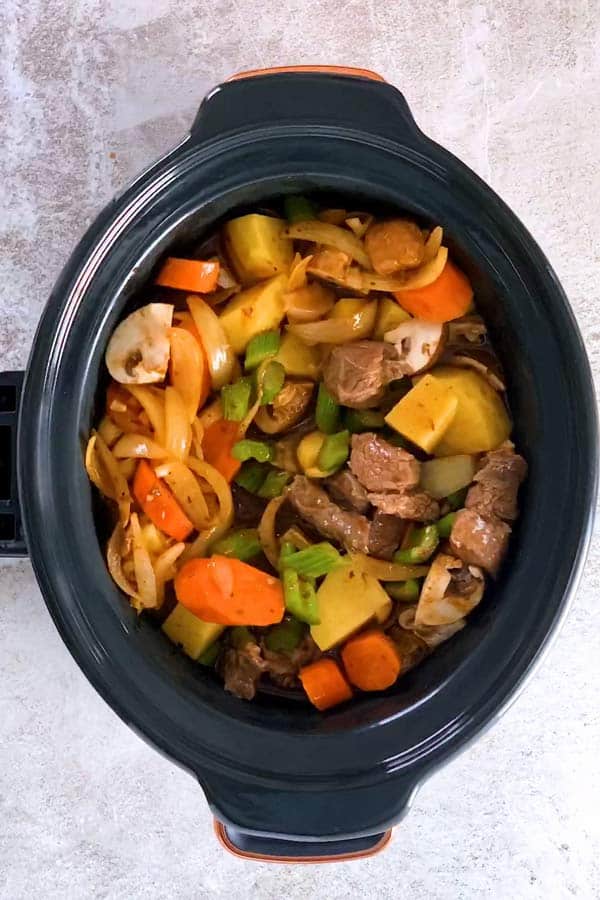 uncooked beef stew in a slow cooker