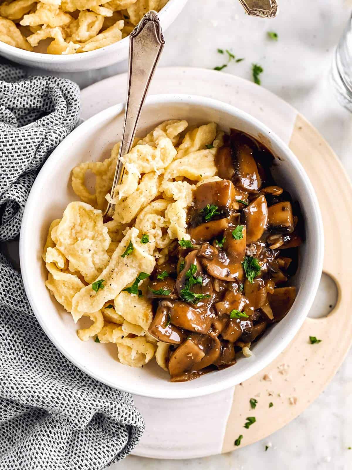 overhead view of white bowl with homemade spaetzle and mushroom gravy