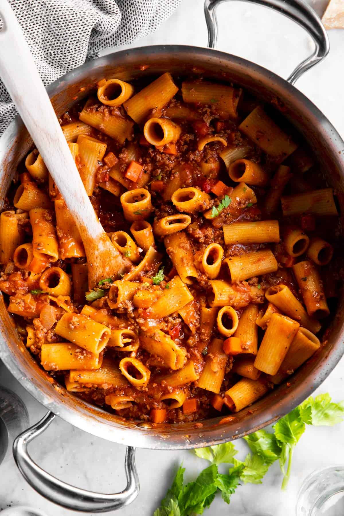 overhead closeup of rigatoni bolognese in sauté pan