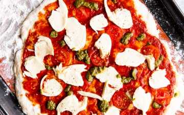 homemade pizza on a baking sheet before baking