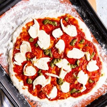 homemade pizza on a baking sheet before baking