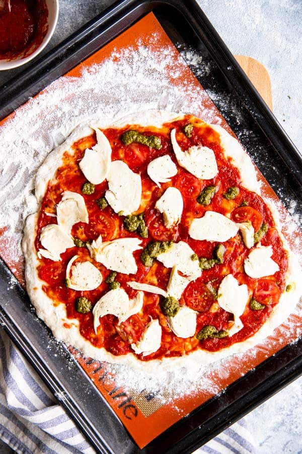 homemade pizza on a baking sheet before baking