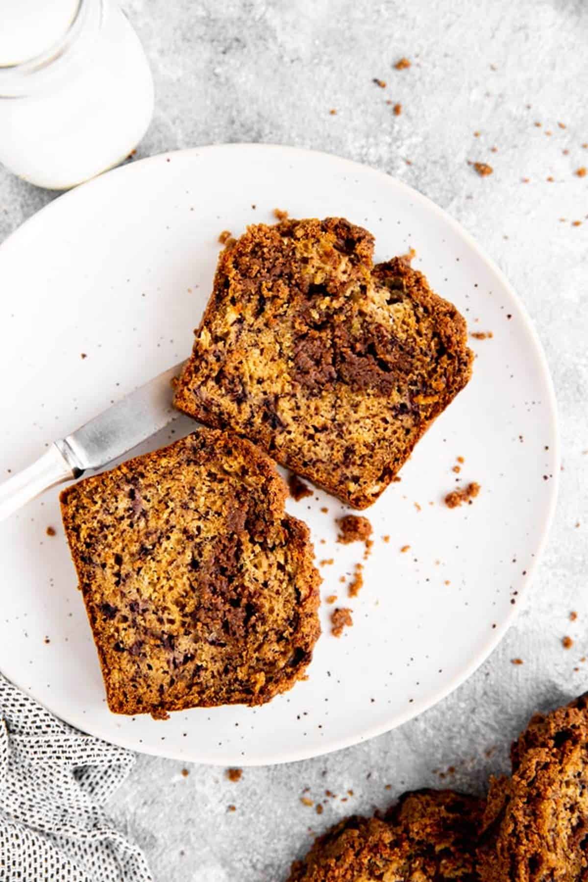 two slices of cinnamon swirl banana bread on a white plate