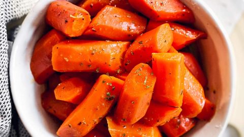 white bowl with glazed carrots on bright surface