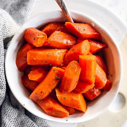 white bowl with glazed carrots on bright surface
