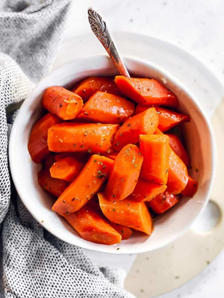 white bowl with glazed carrots on bright surface