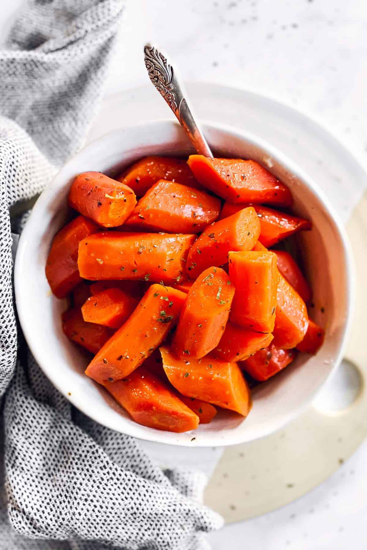 white bowl with glazed carrots on bright surface