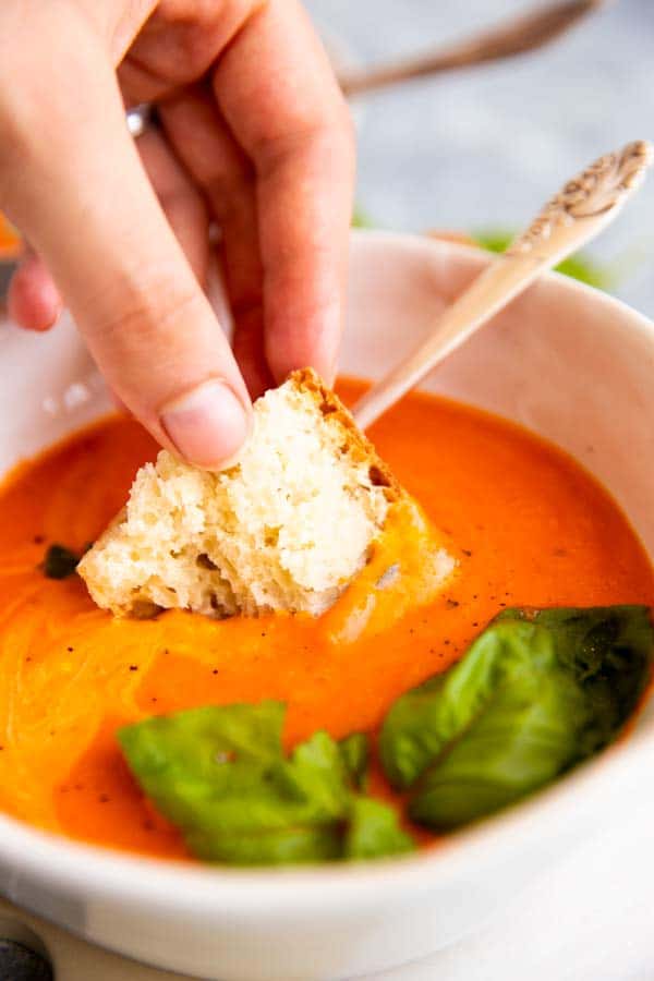 dipping bread in tomato soup