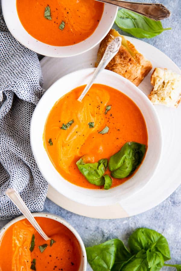 three bowls filled with homemade garlic roasted tomato soup