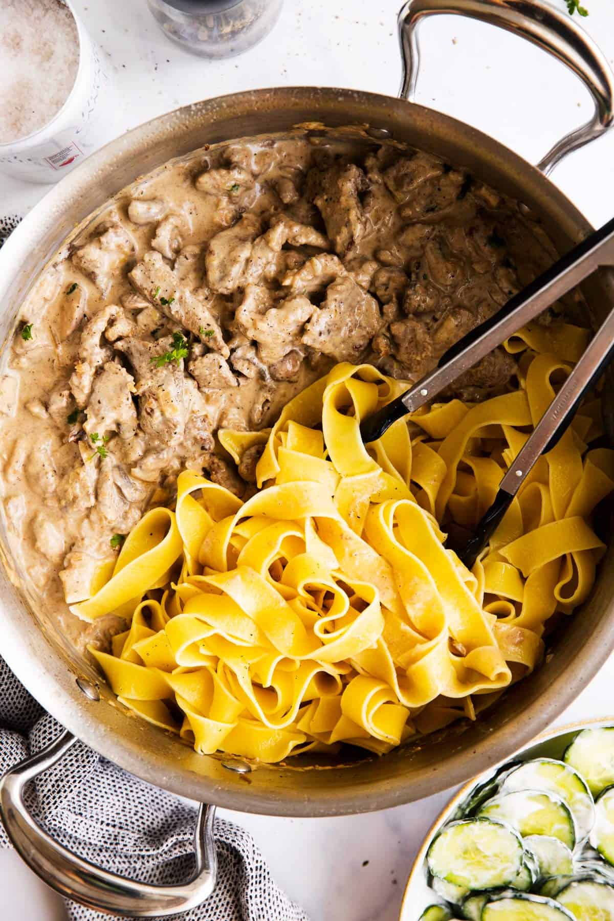 top down view on a skillet with beef stroganoff and buttered noodles