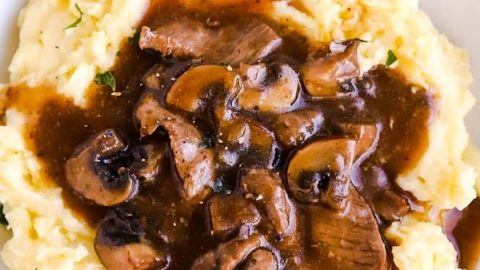 close up photo of a plate with mashed potatoes and beef tips and gravy