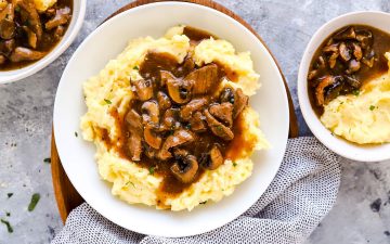 three plates with mashed potatoes and beef tips on a light surface