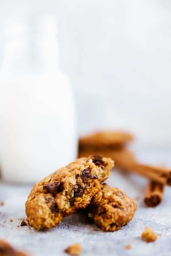 broken up close up photo of a Pumpkin Chocolate Chip Oatmeal Cookies in front of a milk bottle