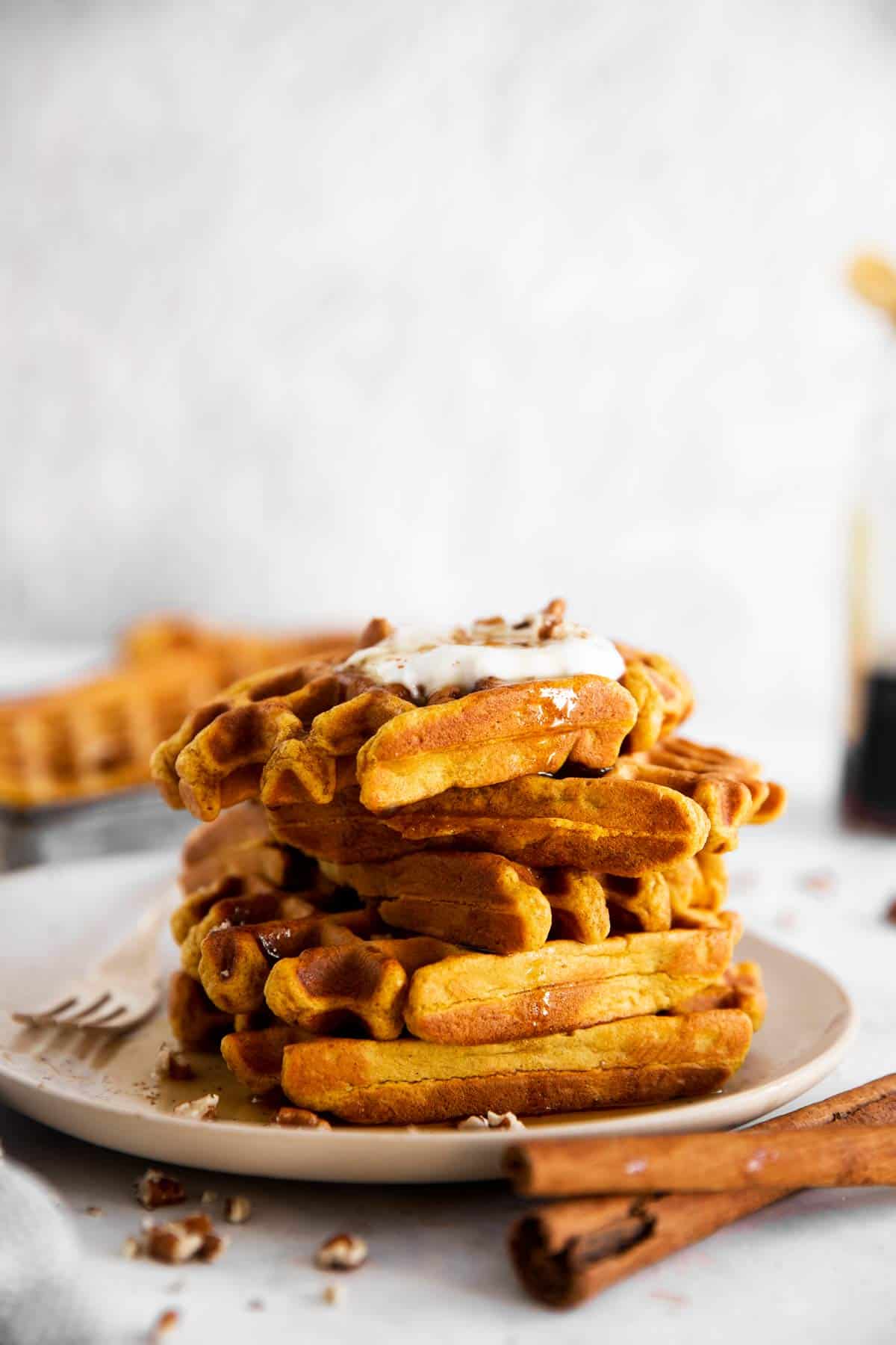 stack of pumpkin waffles on a white plate