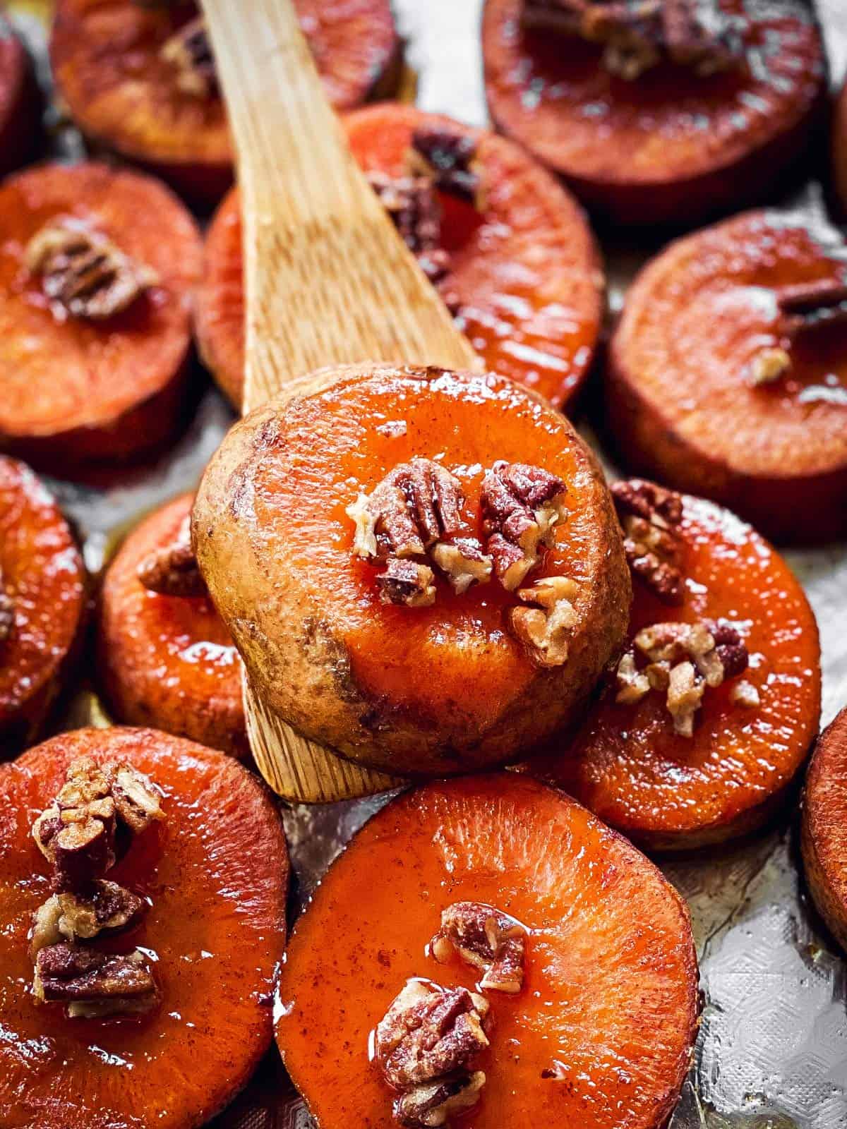 close up photo of sweet potato slice on wooden spoon