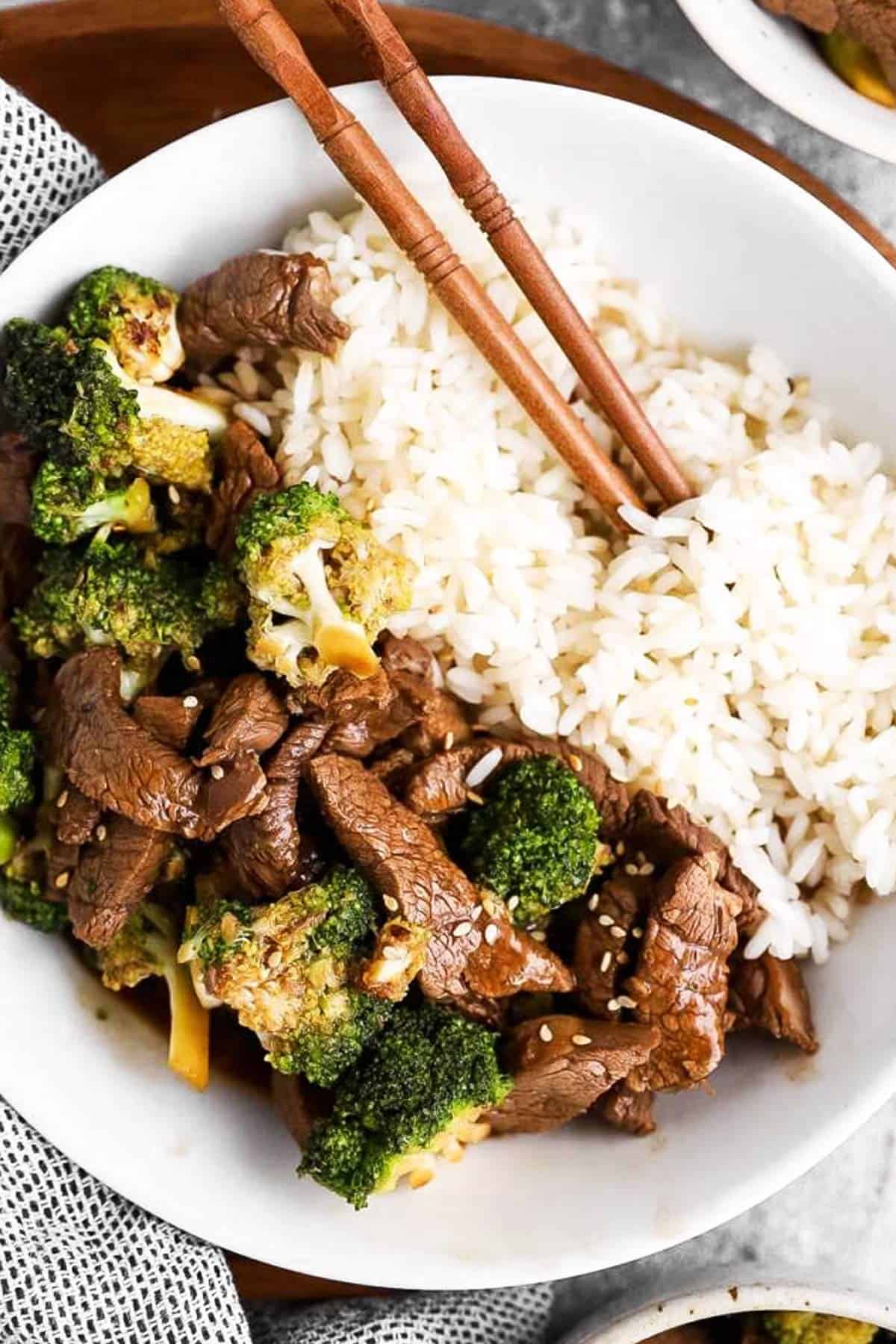 close up photo of beef, broccoli and rice in a white bowl