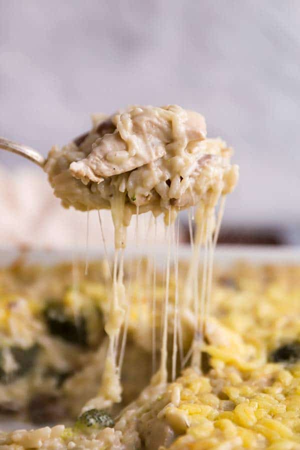 scooping chicken and rice casserole from a dish