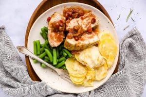 plate with turkey breast, cranberry sauce, scalloped potatoes and green beans