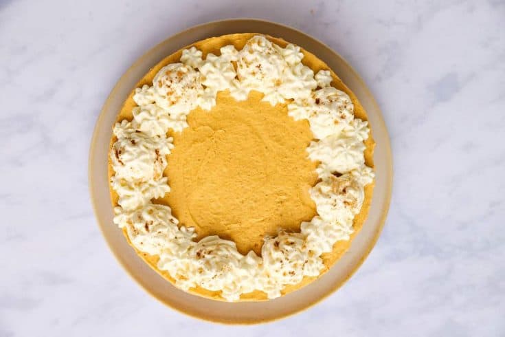top down view of a no bake pumpkin cheesecake garnished with whipped cream