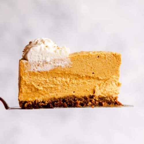 slice of no bake pumpkin cheesecake in front of a light colored wall