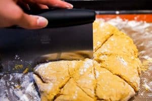 cutting dough into 8 scone wedges with a pastry cutter