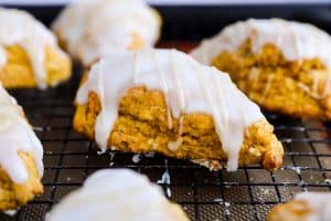 close up photo of a glazed pumpkin scone