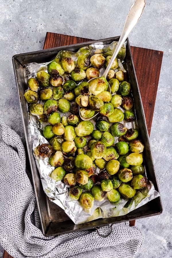 baking pan filled with Brussels sprouts on a wooden board