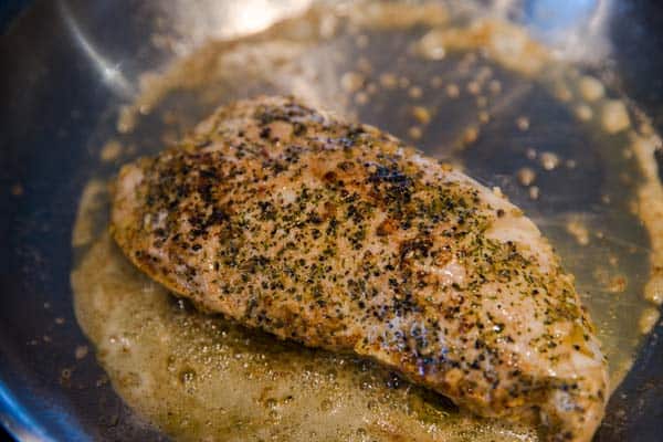 turkey breast searing in a skillet with butter