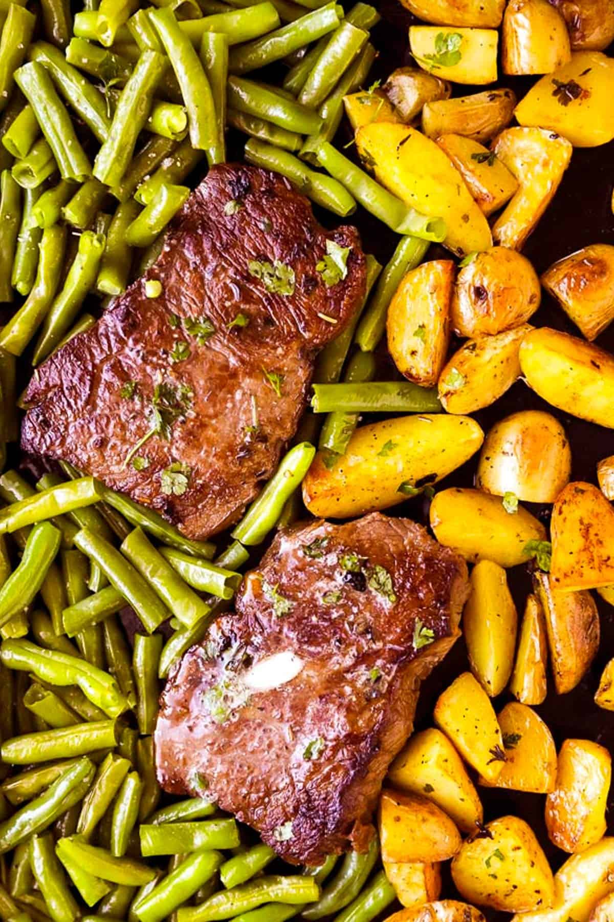 overhead view of potatoes, green beans and steak on sheet pan