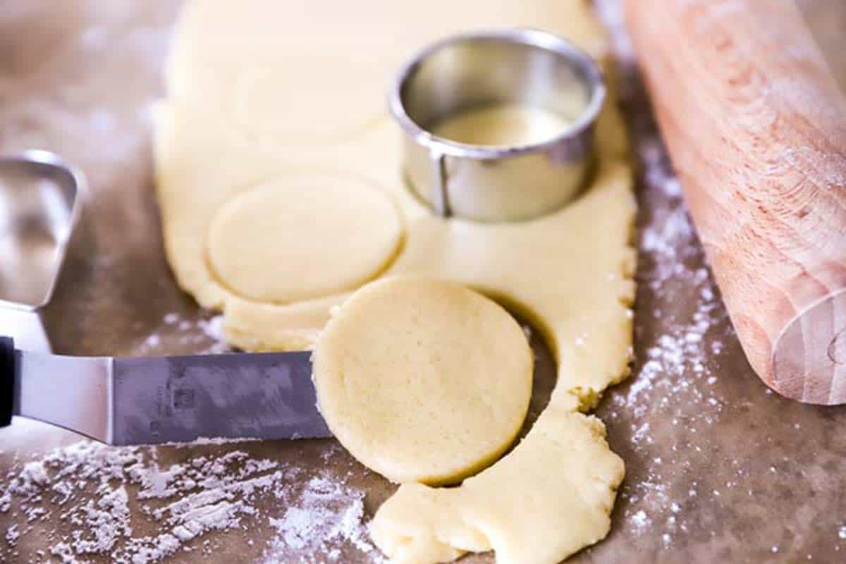 cutting out sugar cookies from rolled out dough