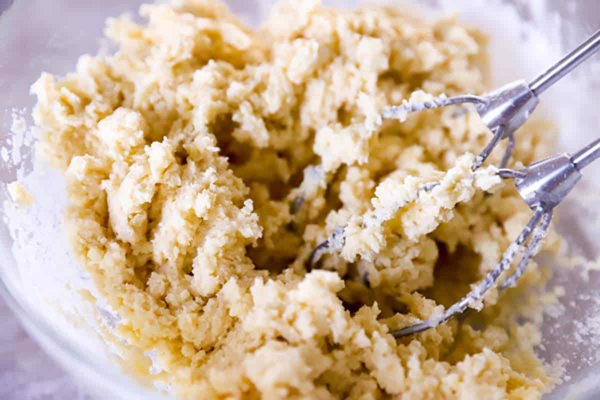 beaters in a bowl with sugar cookie dough